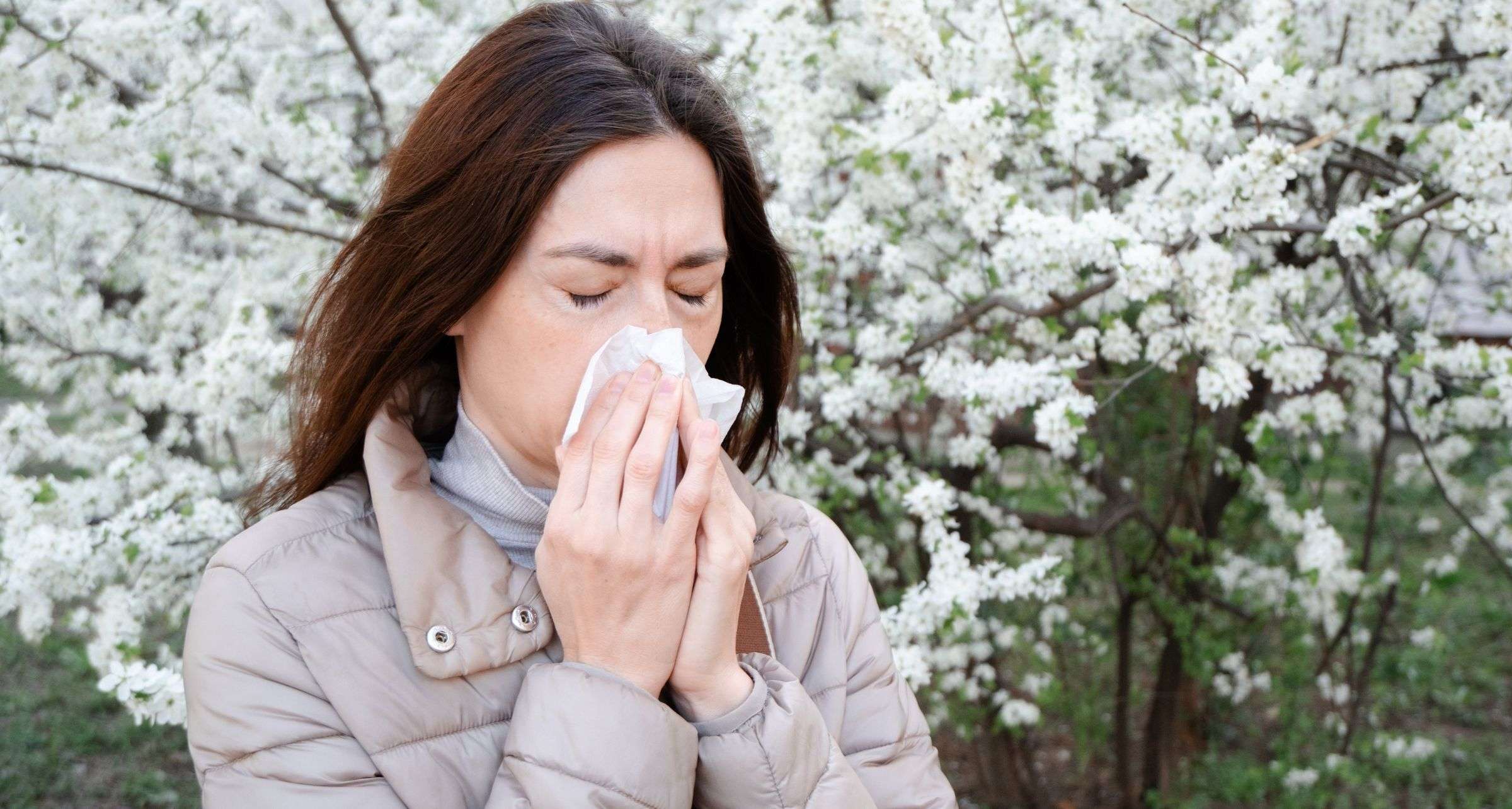 Ragazza si soffia il naso per allergie